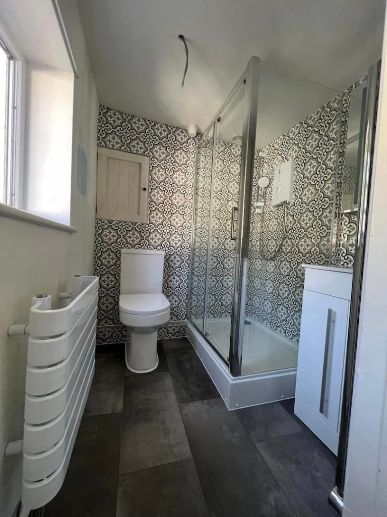 Bathroom with shower cubicle and tiled walls